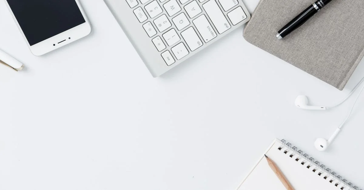 Vue plongeante d'un espace de travail moderne et minimaliste avec des gadgets et des fournitures de bureau sur une table blanche.