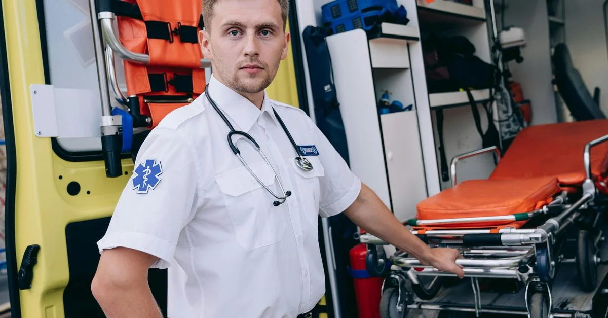 Paramédic en uniforme prépare un brancard à l'intérieur d'une ambulance pour une intervention d'urgence.
