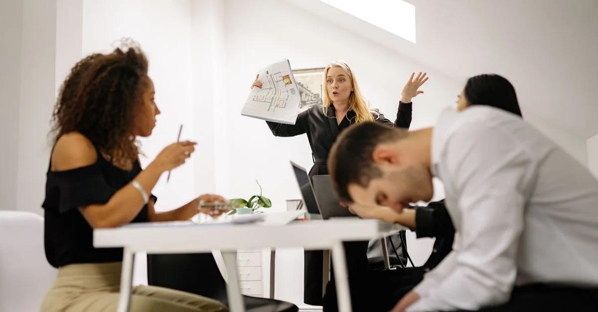 Équipe ressentant du stress pendant une réunion de bureau animée. Des collègues divers s'engagent dans une discussion émotionnelle à l'intérieur.